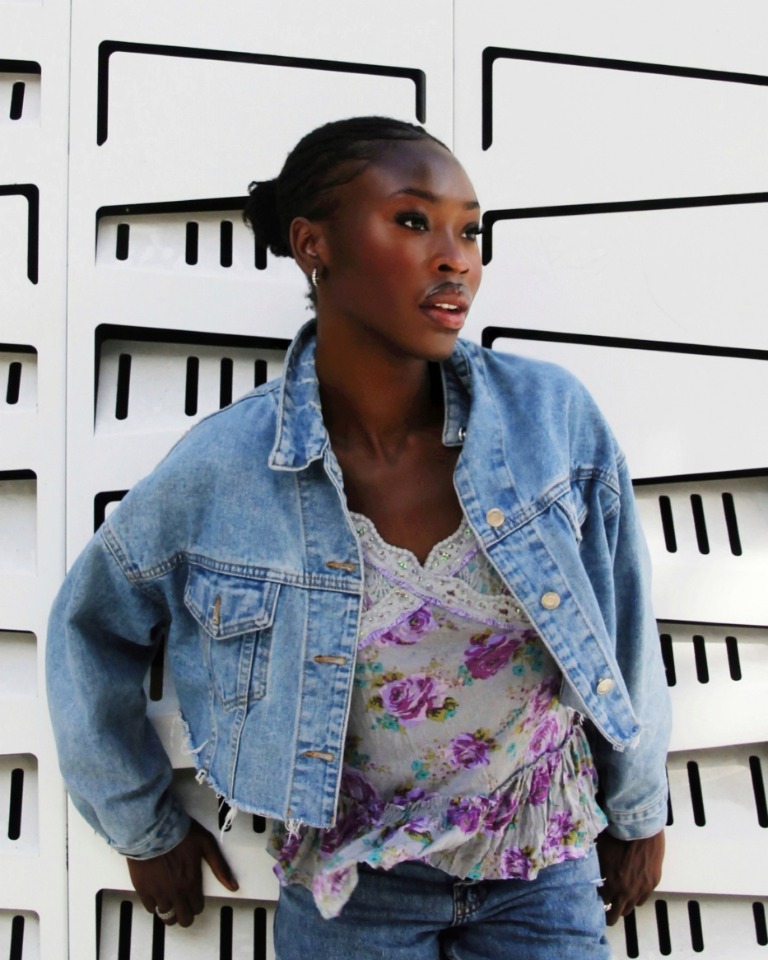 Fashion portrait in a denim jacket against a graphic wall