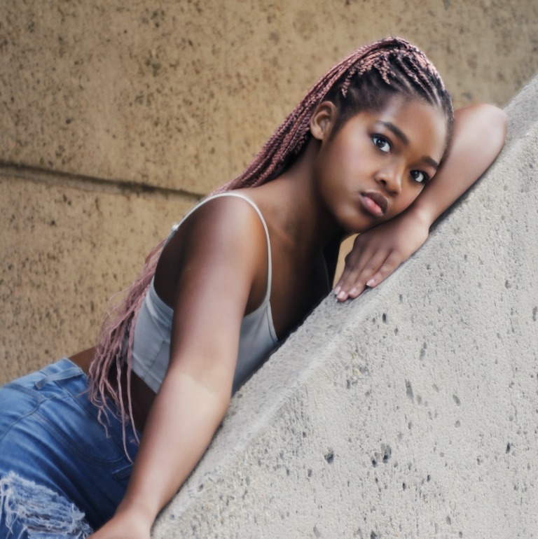 Headshot leaning against a textured stone wall
