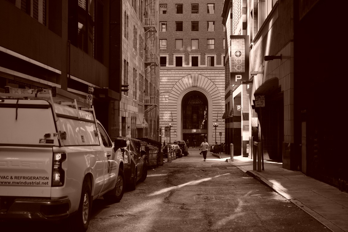 Warm-toned downtown alley framed by city buildings