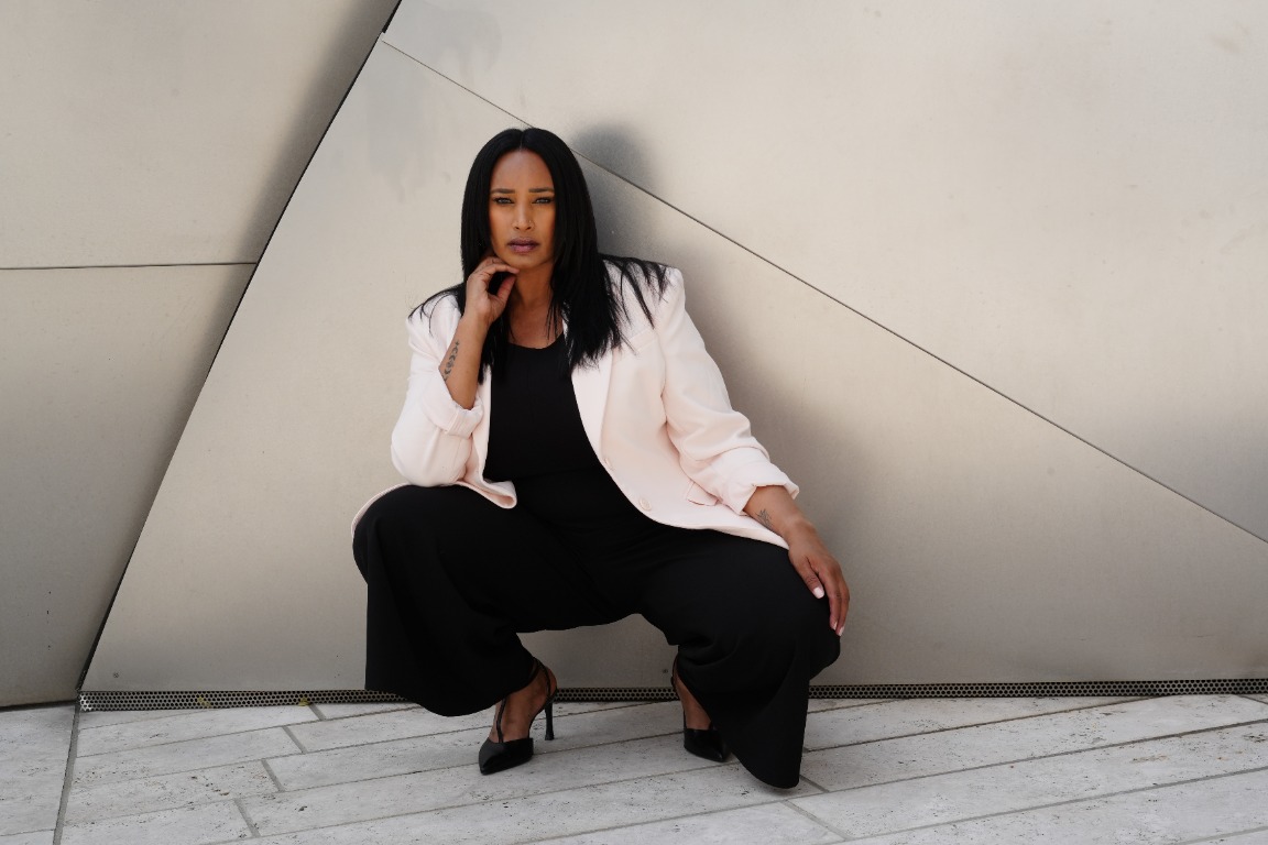 Portrait in a white blazer against sculptural architecture