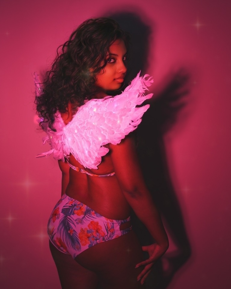 Pink-lit fashion portrait with feathered styling
